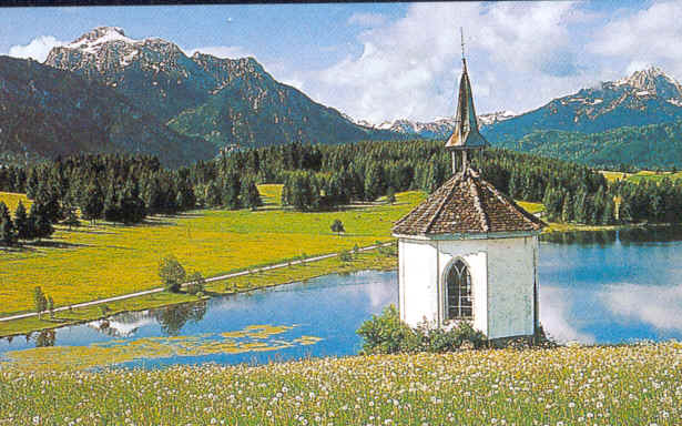Mountain view over pond with Bavarian style chapel